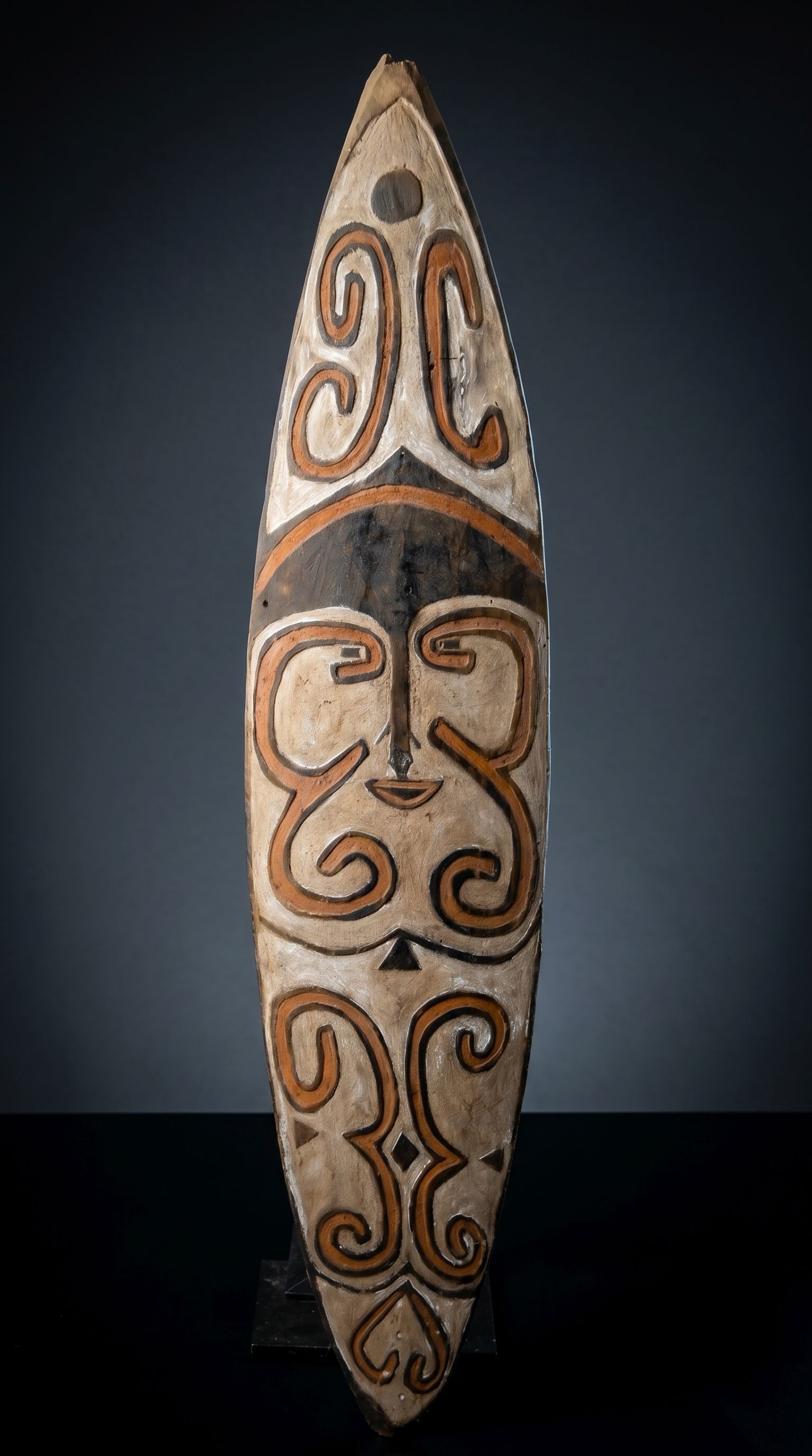 A Kikori Gope Board from Papua New Guinea: A Kikori area spirit board (Gope), Gulf province Papua New Guinea. (C. 20th Century).This carved wooden board of classical style for the region, with central stylized face surrounded by zigzag linear 