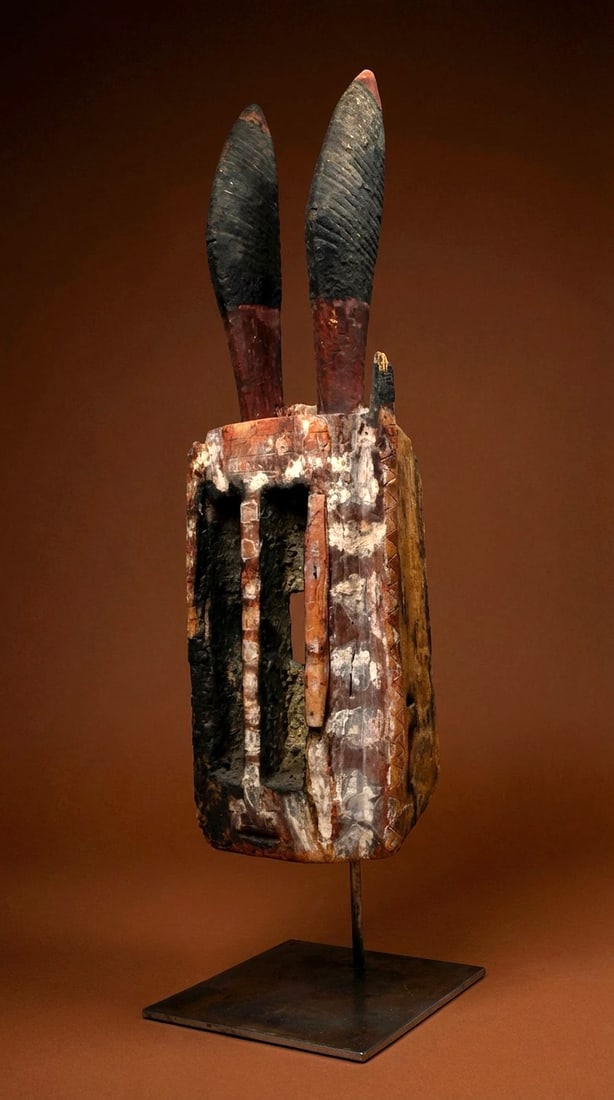 A Dogon Walu Mask: A old and weathered carved wooden Walu or Antelope mask with highly stylized form, wide open work eyes and a very weathered surface. According to Dogon beliefs, The Dogon Walu mask would be danced wit