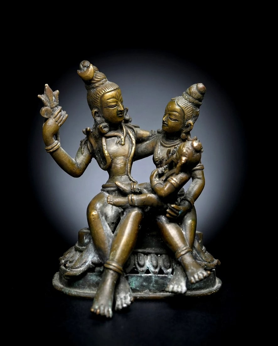 Antique Hindu Trinity Shiva, Parvati & Ganesh Bronze sculpture: A very finely crafted antique bronze Trinity Sculpture from Nepal. A bronze depiction of the Shiva Parivar (Shiva's divine family)—comprising Lord Shiva, his consort Goddess Parvati, and their eleph