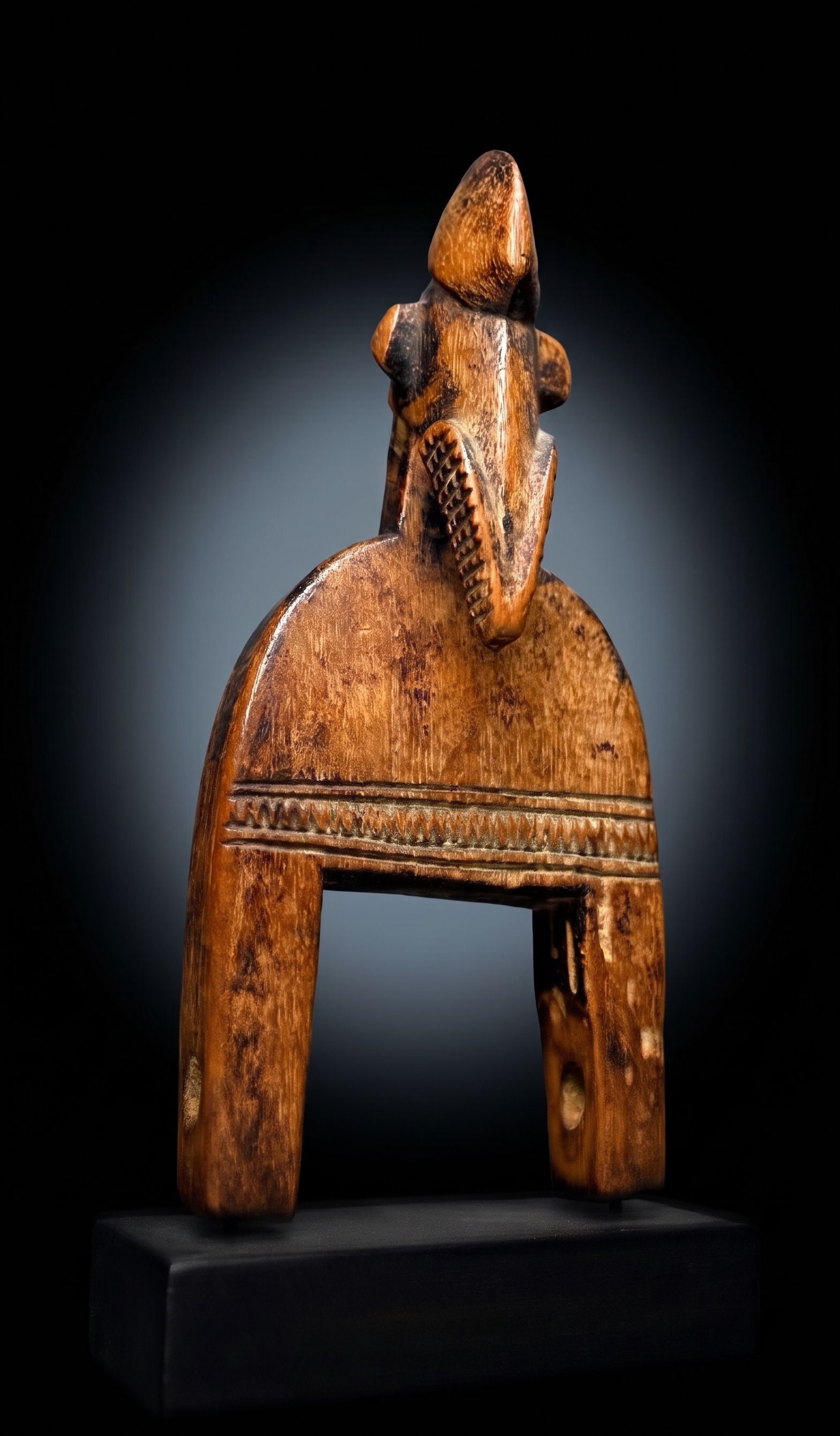 Old Senufo Weaving Pulley: A carved wooden weaving pulley with incised linear designs and a classic hornbill style bird head on top as the central motif. The Pulley measures 7.75 inches tall on wooden base. Senufo peoples, Ivor