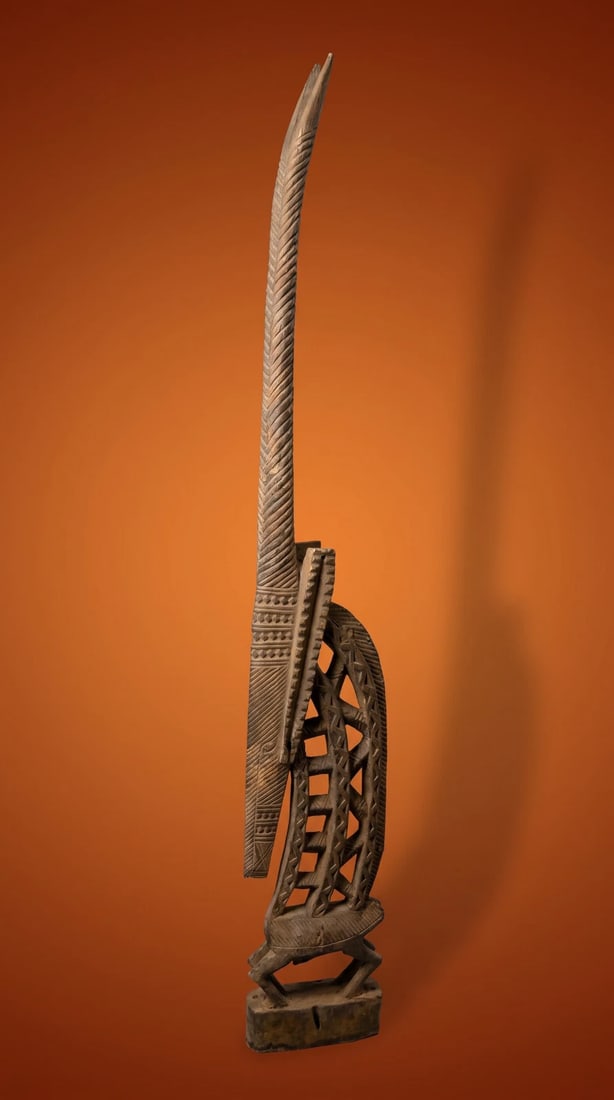 A Tall Slender Bambara Chiwara Sculpture: A highly stylized carved wooden dance crest in the form of a tall slender antelope, with wonderful openwork design and well weathered surface. The Headdress measures 43 inches tall. Bamana / Bambara p