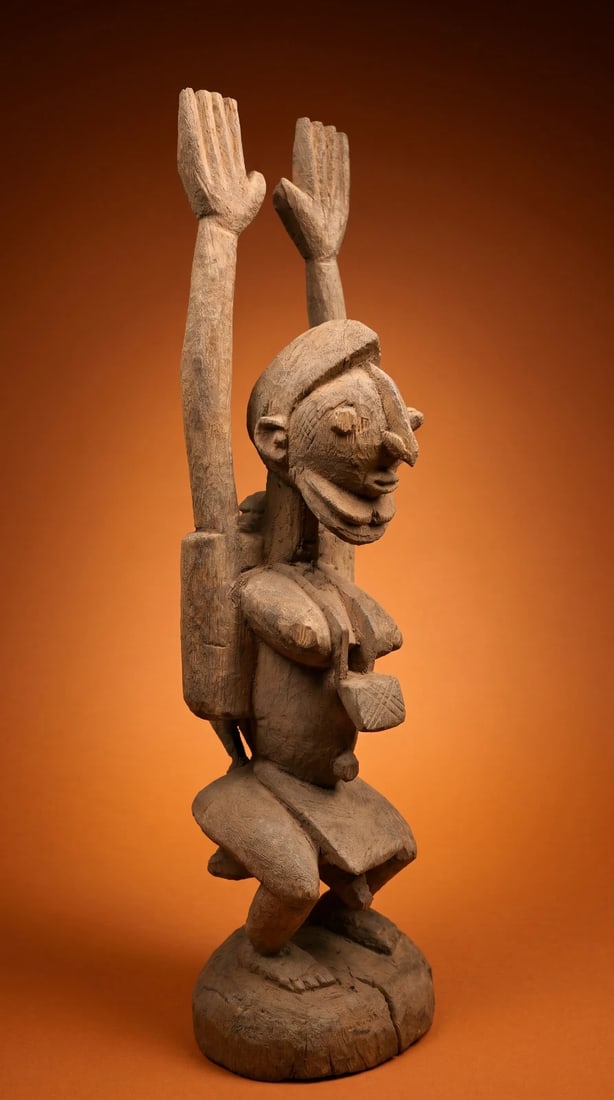 A Dogon Hermaphrodite Sculpture: A contemporary sculpture of a stylized hermaphrodite effigy with male and female features and shown as a Nommo or ancestor, with hands in the air as a form of prayer for rain. Dogon peoples, Mali, Wes