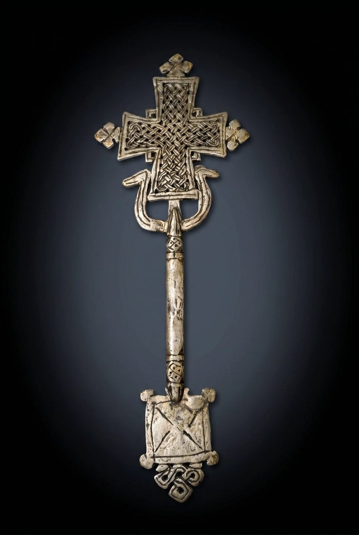 Ethiopian Hand Cross: The is a silver hand cross from the Coptic Church in Ethiopia. Such crosses are carried by priests in religious processions and given as gifts to reward the faithful. It is a religious artifact used i