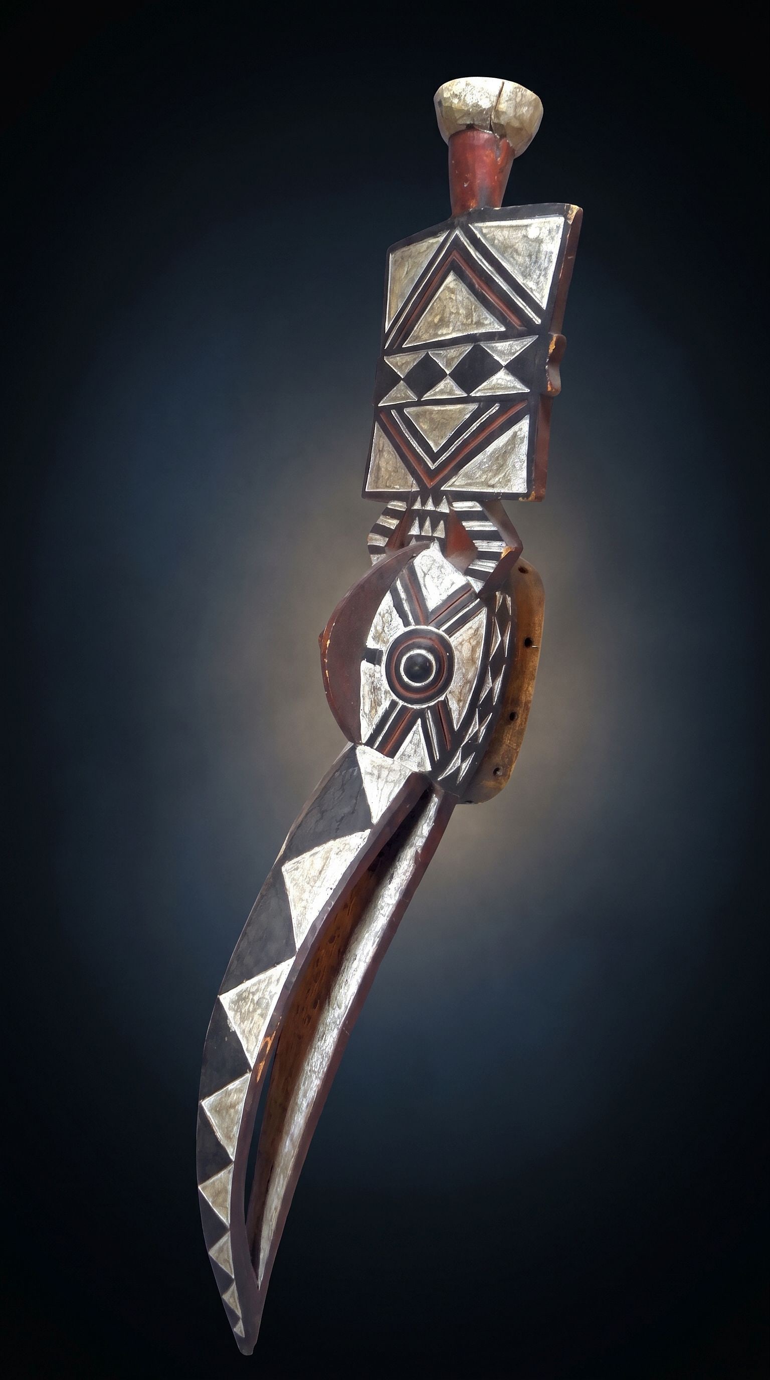 A Bwa Bird Mask: A tall carved wooden vintage avian mask with bold incised and painted designs in red, black and white colors. The mask was collected in the 1980s and has been in a private New York state collection fo