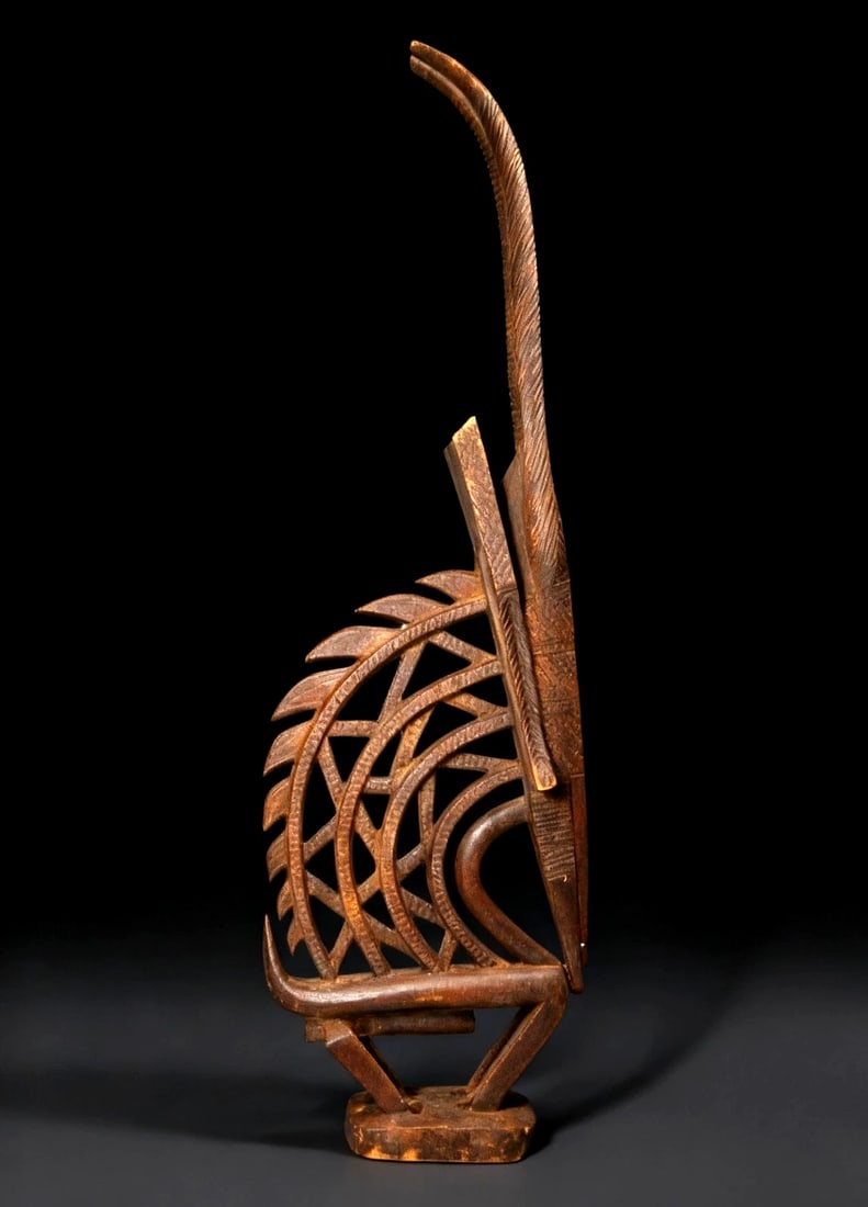 A Bamana Chiwara Ex Museum 1972: A Finely carved Chiwara antelope headdress in classic form with openwork design and incised details. This is a traditional wooden, antelope-shaped sculpture that represents a mythical being. Part huma