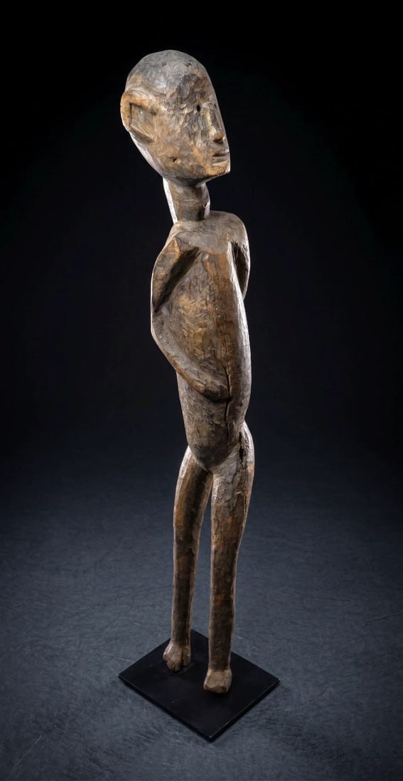A Nyamwezi Twisted Ancestor Sculpture: A tall slender carved wooden abstract figure with a stylized natural twistedform. The Nyamwezi, historically known as the "People of the Moon", are Tanzania's second-largest ethnic group. Celebrated f