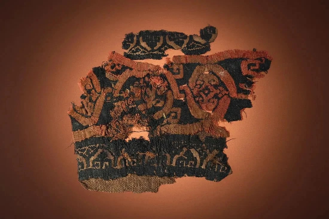Ancient Coptic Textile Fragment from Egypt 3rd to 5th Century: Ancient linen fragment, likely from a tunic, with a repeating band of geometric linear designs in red and brown colors. Coptic peoples, 3rd to 10th century, Egypt. The fragment measures 5.5 x 5 inches