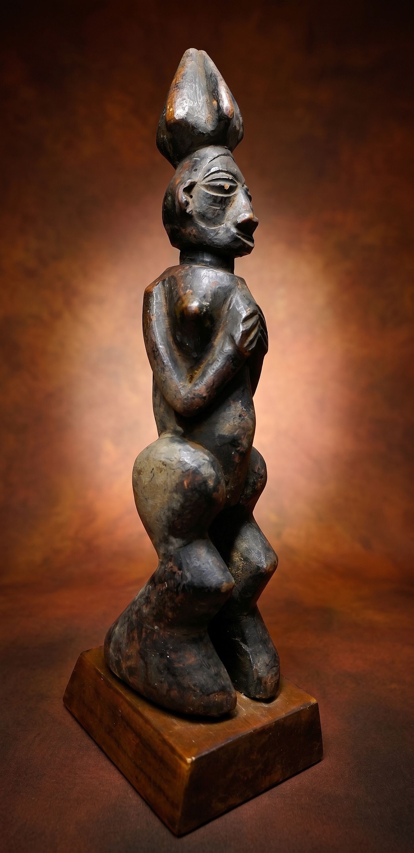 A Yaka Female Sculpture: A highly stylized carved wooden female effigy with a well handled surface and wonderful form. Yaka peoples, DRC/ Congo, central Africa. The figure measures 12.5 inches tall on custom display stand. Pr