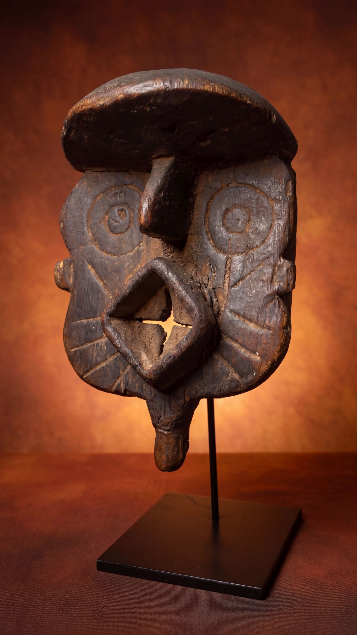 A Bwa African mask: A very well used old carved wooden ceremonial mask with highly stylized facial features, incised linear designs and a deep well handled and worn surface patina. Bwa peoples, Burkina Faso, West Africa.