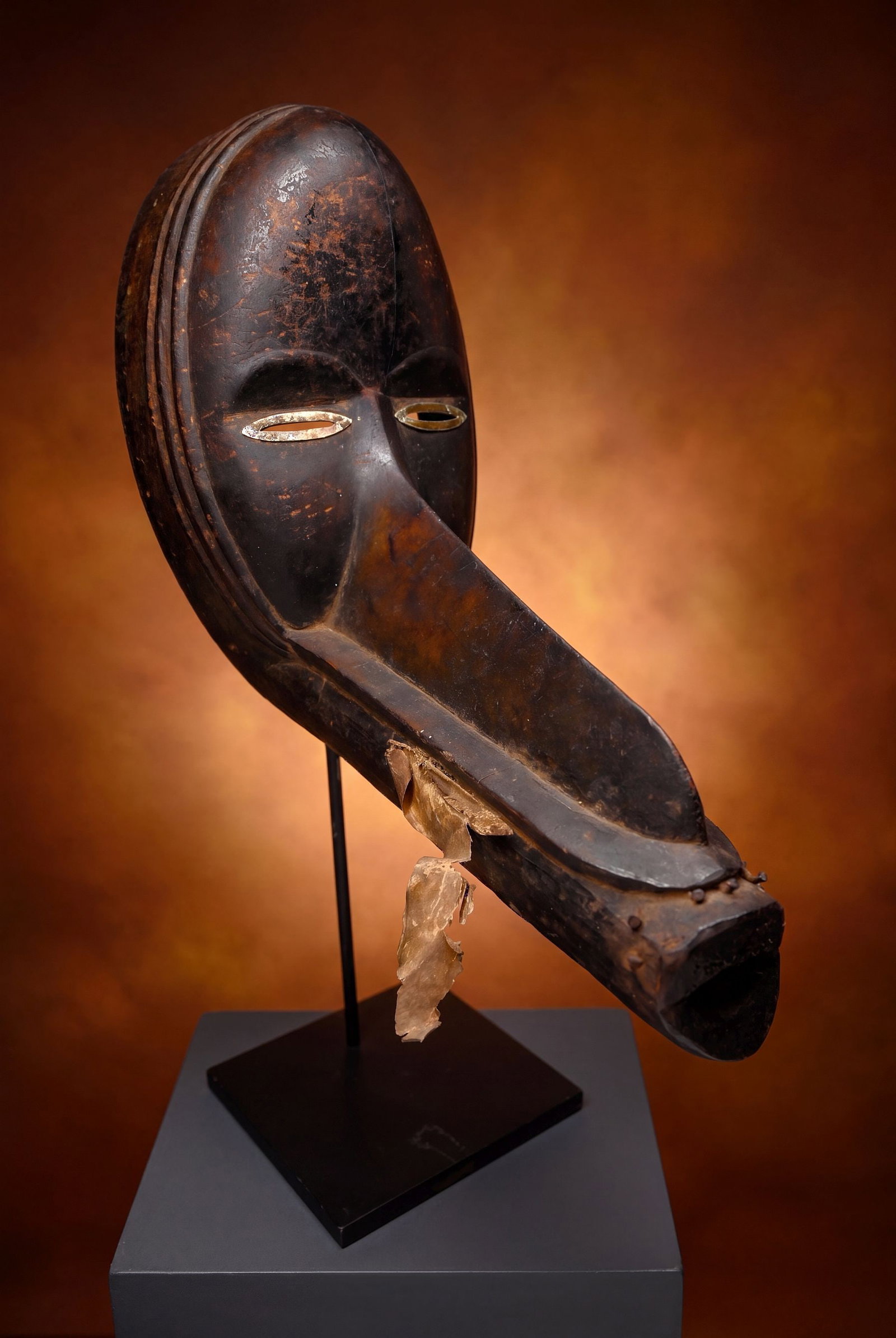 A Dan Gagon Mask, African Art: A carved wooden ceremonial dance mask with elongated bird like beak and remains of animal hides that were once attached. Dan peoples, Ivory Coast, West Africa. The mask measures 10.25 x 10 inches , 17