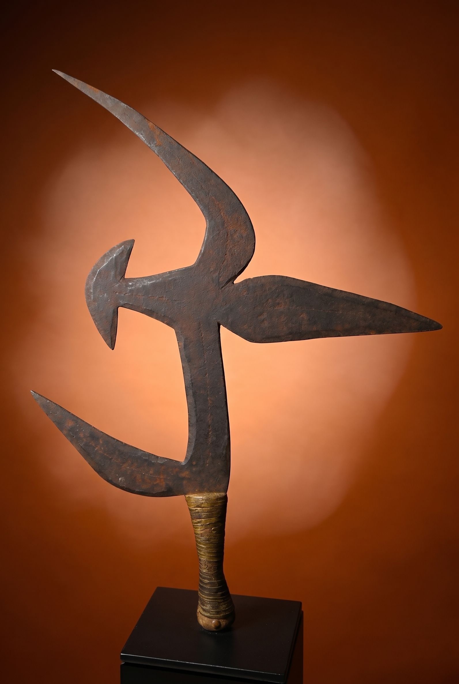 A Ngbaka Mabo Throwing Knife: A hand Forged Iron sword or knife in an abstract form, known locally as Moko Ndo, and would serve as a symbol of status among the tribe as well as a currency form. The Knife measures 20 x 14 inches on