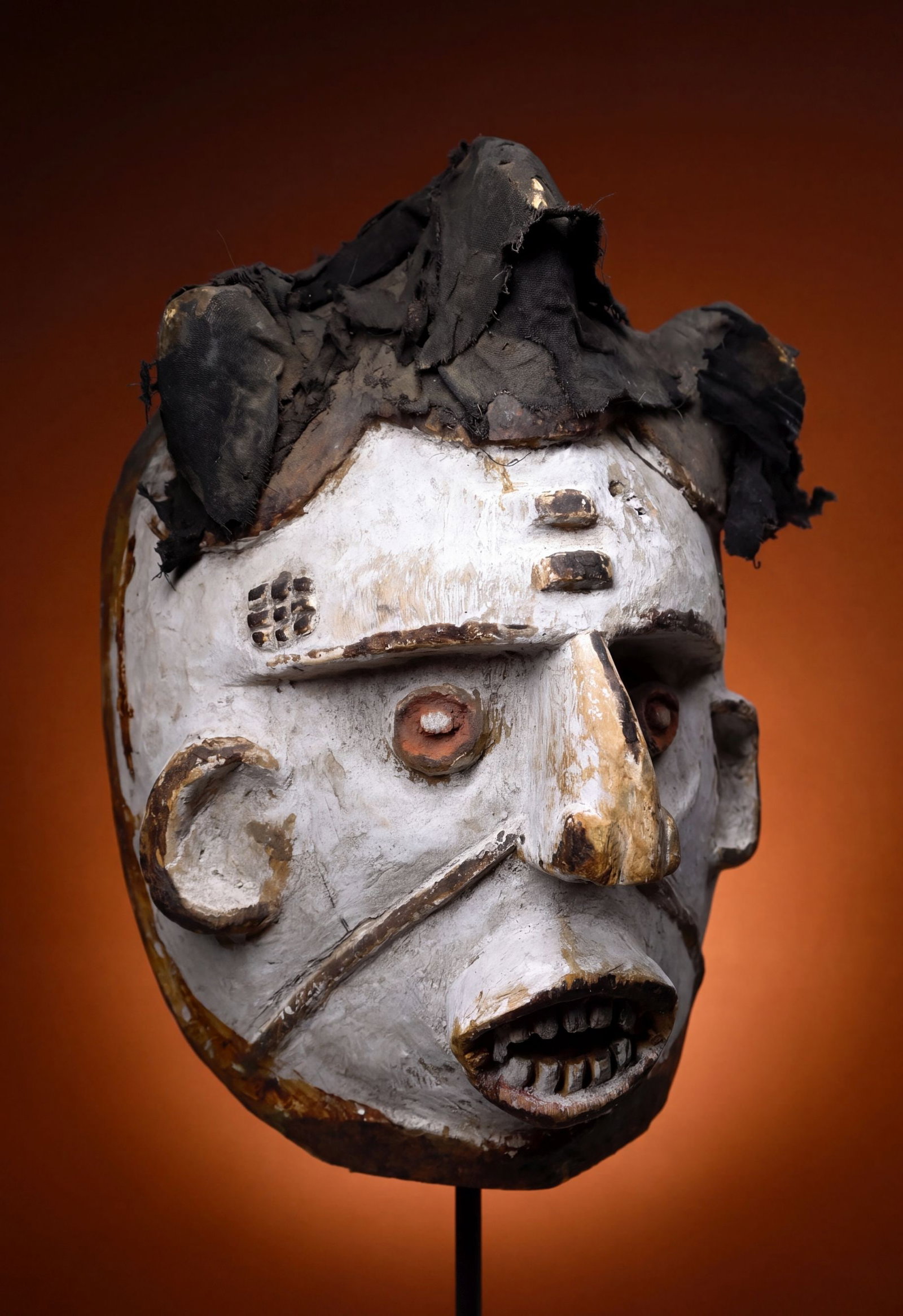 A Dramatic Idoma African Mask: A carved wooden ritual mask with a strong painted white kaolin surface and protruding eyes as well as traditional scar designs. Idoma peoples, Cross River region, Nigeria, West Africa. The mask measur