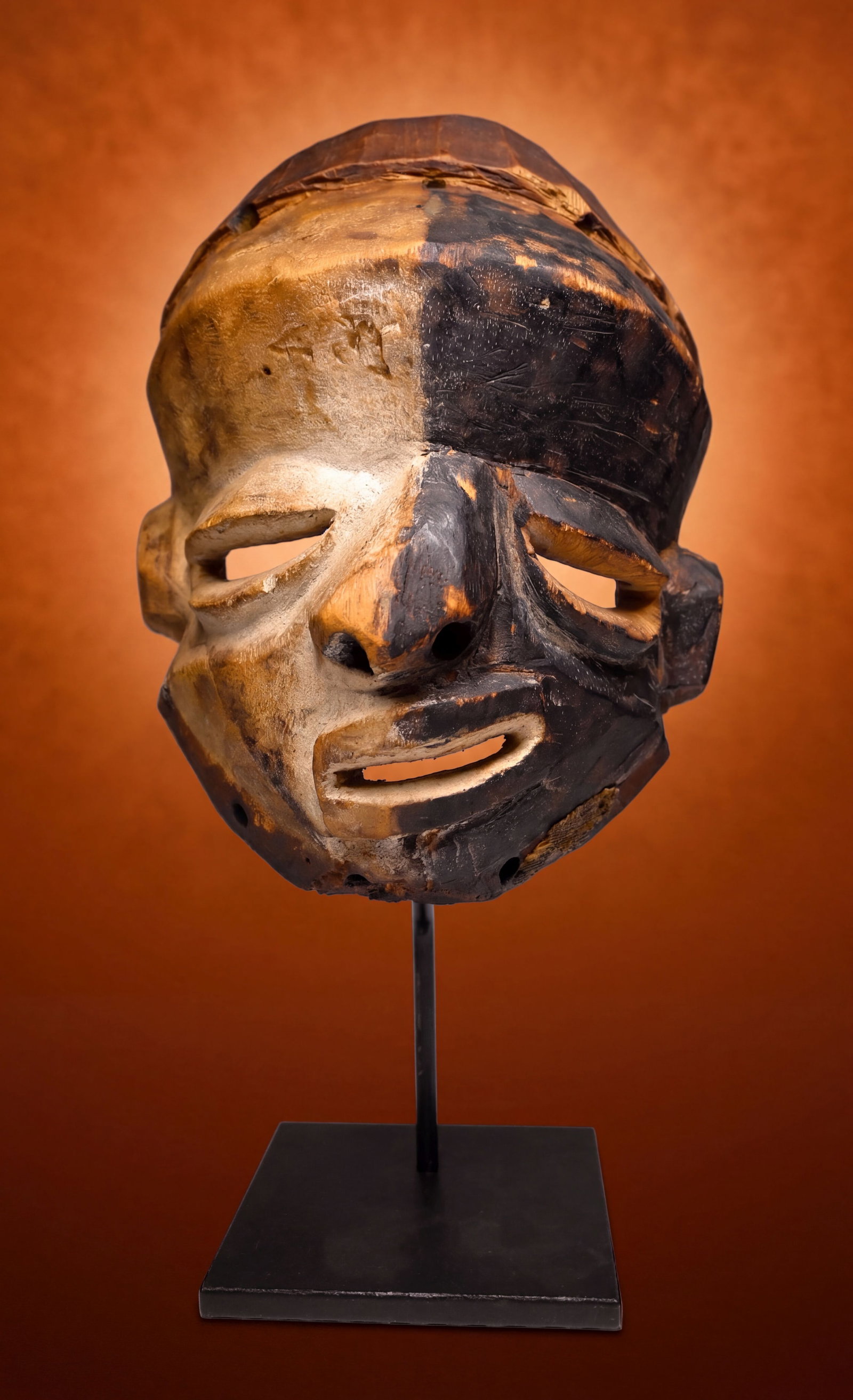 A Pende Mbangu Illness Mask: A carved wooden ceremonial mask representing a person afflicted with Illness, Paralysis and disease. The contrasting black and white colors have different meanings, the white kaolin clay used in heali