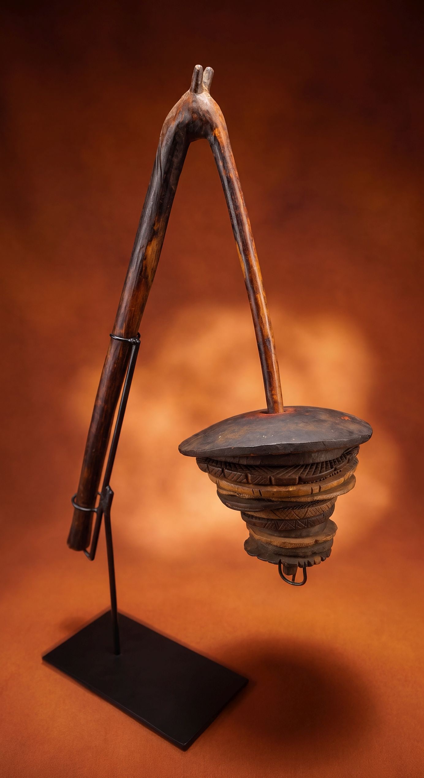 A Dogon Sistrum or Disc Rattle: A old carved wooden clapper style disc rattle or sistrum with a small horned effigy on top and well handled surface patina. Dogon peoples, Mali, West Africa. The rattle measures 22 x 12 inches and has
