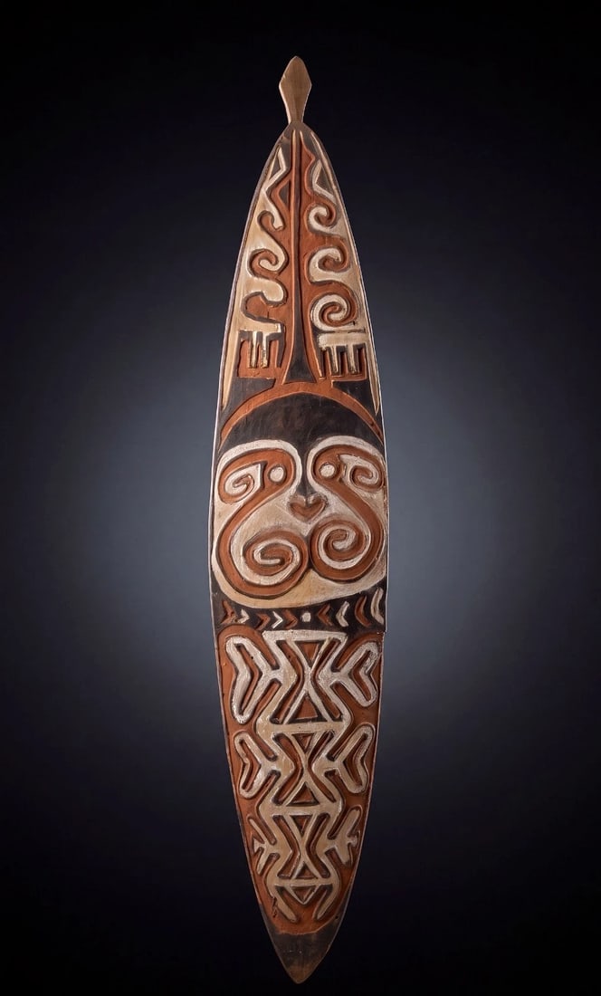 Elaborate Kikori Gope Board: A Kikori area spirit board (Gope); Gulf province Papua New Guinea. (C. 20th Century) A tall carved wooden panel of typical form for the type, the board in a rust color with black and white designs whi
