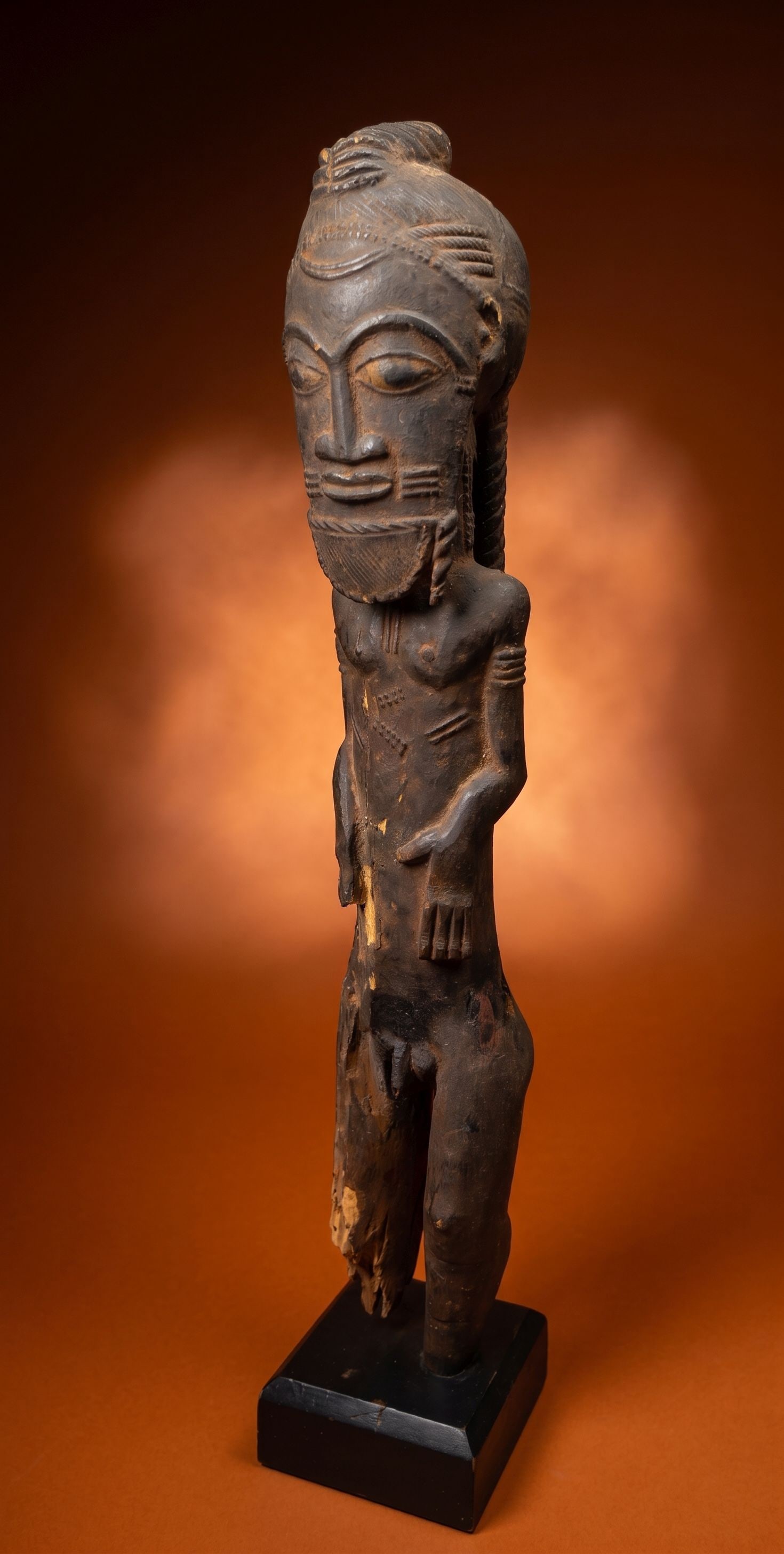 Eroded Old Baule Male Ancestor Effigy: A carved wooden male effigy with wonderful facial style, elaborate carved details and obvious weathering and age. This male sculpture possibly represents an asye usu which is a nature/bush spirit hous