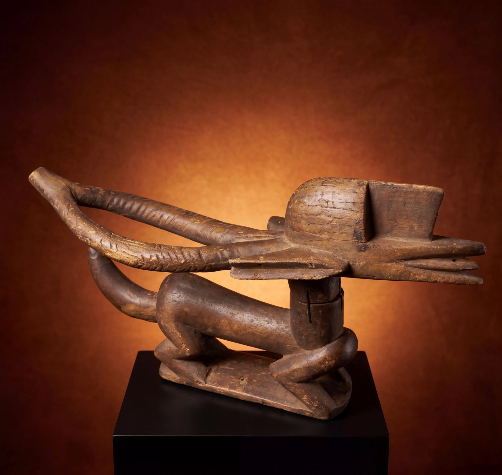 A Bamana Chiwara Sculpture: A carved wooden sculpture of a stylized antelope with a deep well handled surface patina, that was traditionally worn atop the head on a basketry cap. Danced in agricultural festivals and other ceremo