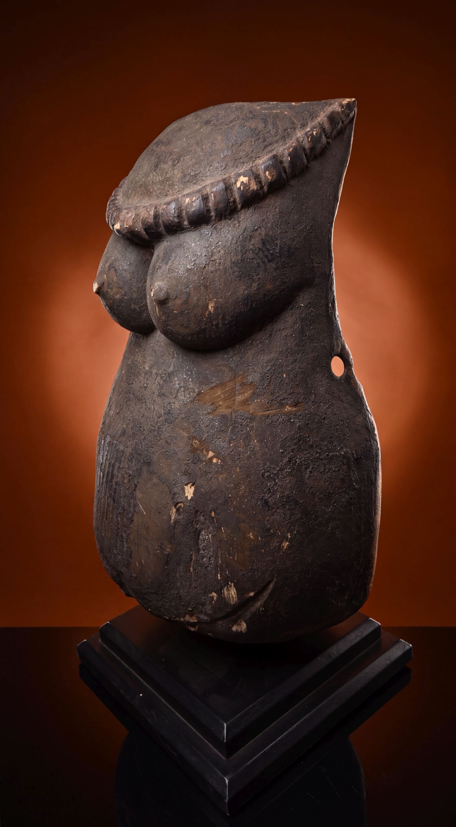 A Makonde Ndimu Body Mask: A carved wooden dance mask worn on the chest of a male dancer during ceremonial dances after the initiation rites of the Lipiko rituals. Known locally as Njorowe or Ndimu, this is a hollowed out