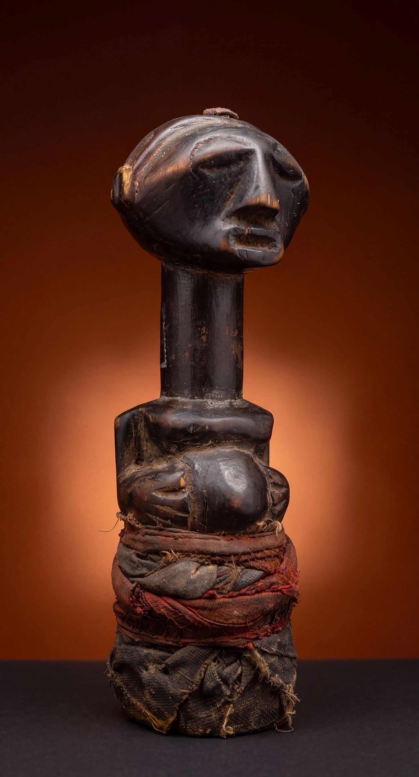A Songye Fetish Idol: A small carved wooden magic fetish with deep oily , sweating surface suggesting age and use as a ritual object. The sculpture measures 7 inches tall. Songye peoples, DRC/ Congo, central Africa.
