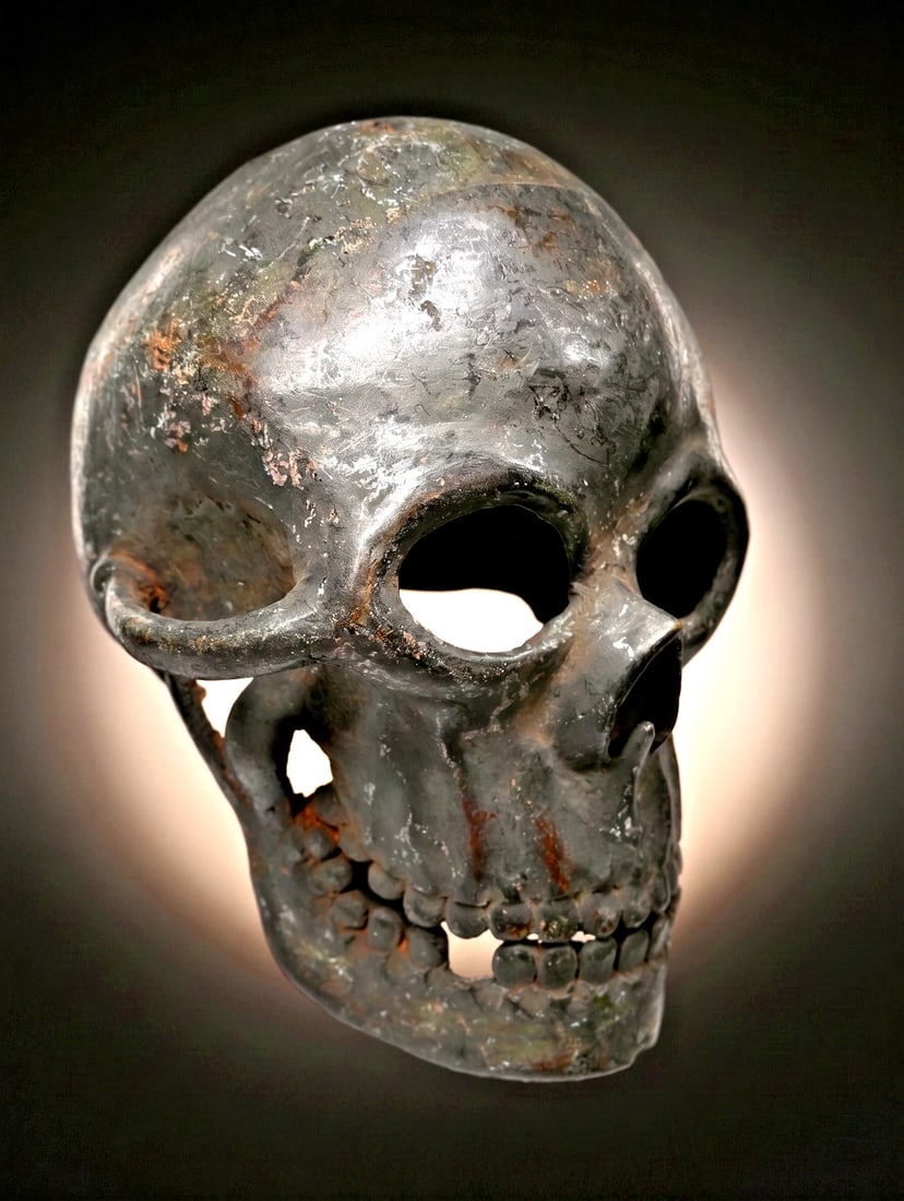 A Large Bronze Skull: A vintage cast bronze sculpture of a human skull, created larger than life size with a very realistic form and overall style. Bamileke or related peoples, Cameroon, West Africa. The sculpture