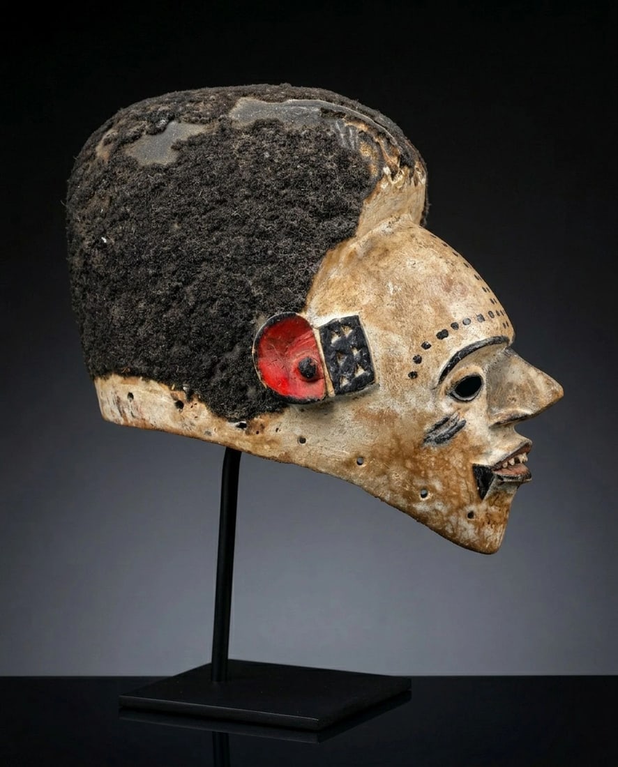 Old Idoma Ceremonial African mask: Expertly carved from wood, this thin walled mask was painted with kaolin clay pigments and adorned with human hair and painted designs. Idoma peoples, Cross River, Nigeria. The mask measures 8.5 x 10 