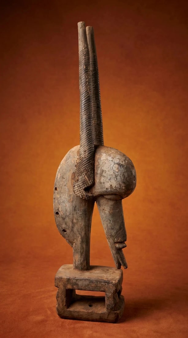 A Bamana Chiwara Antelope Headdress: A highly stylized and well used carved wooden dance crest in the form of a antelope, with wonderful form and well weathered surface. The Headdress measures 23 inches tall. Bamana peoples, Mali, West A