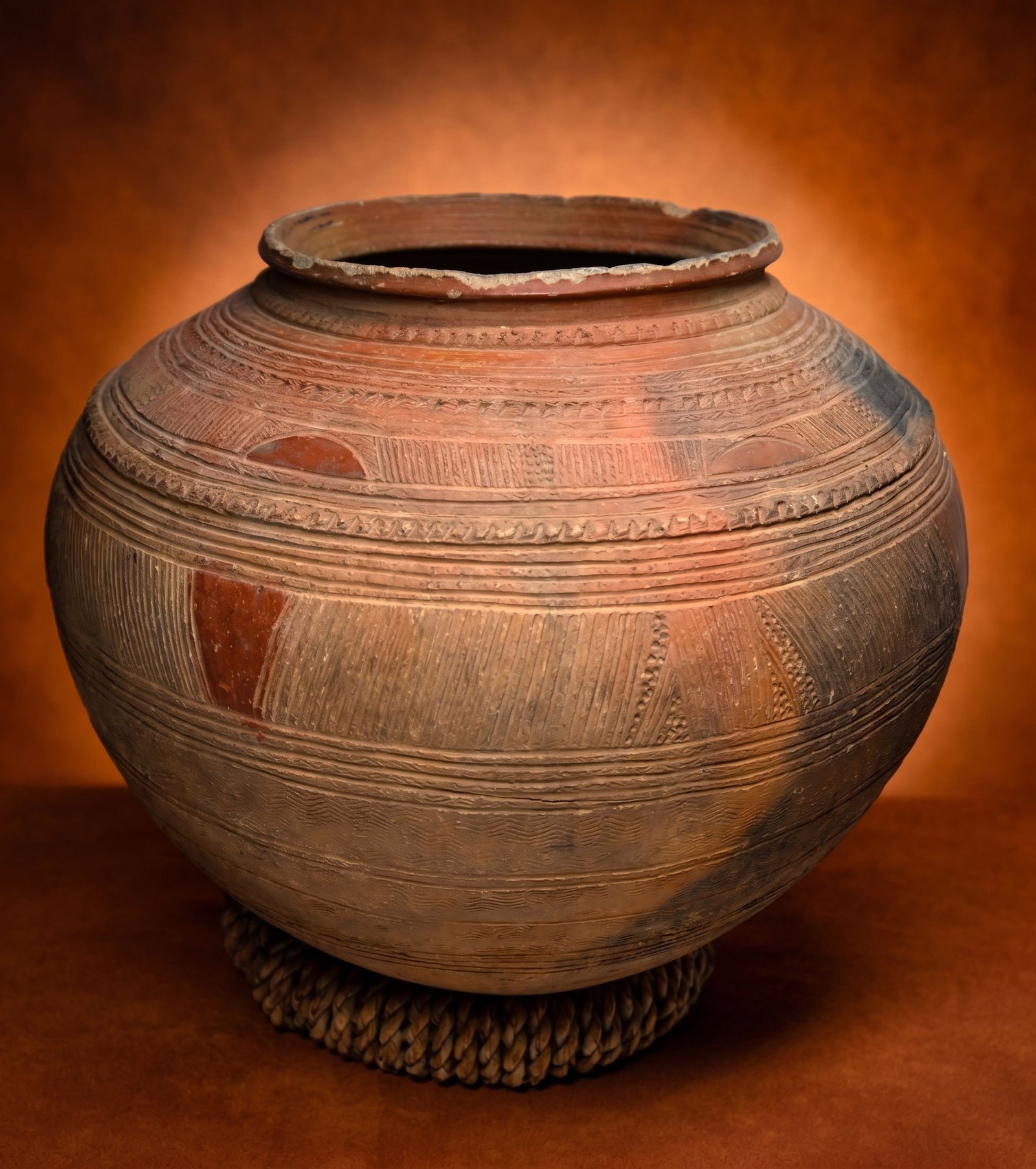 A Nupe Terracotta Pot: A hand made and incised large terracotta pottery bowl with finely etched designs throughout. Nupe peoples, Nigeria, West Africa. The Pot has some rim chipping consistent with field use. The Pot measur