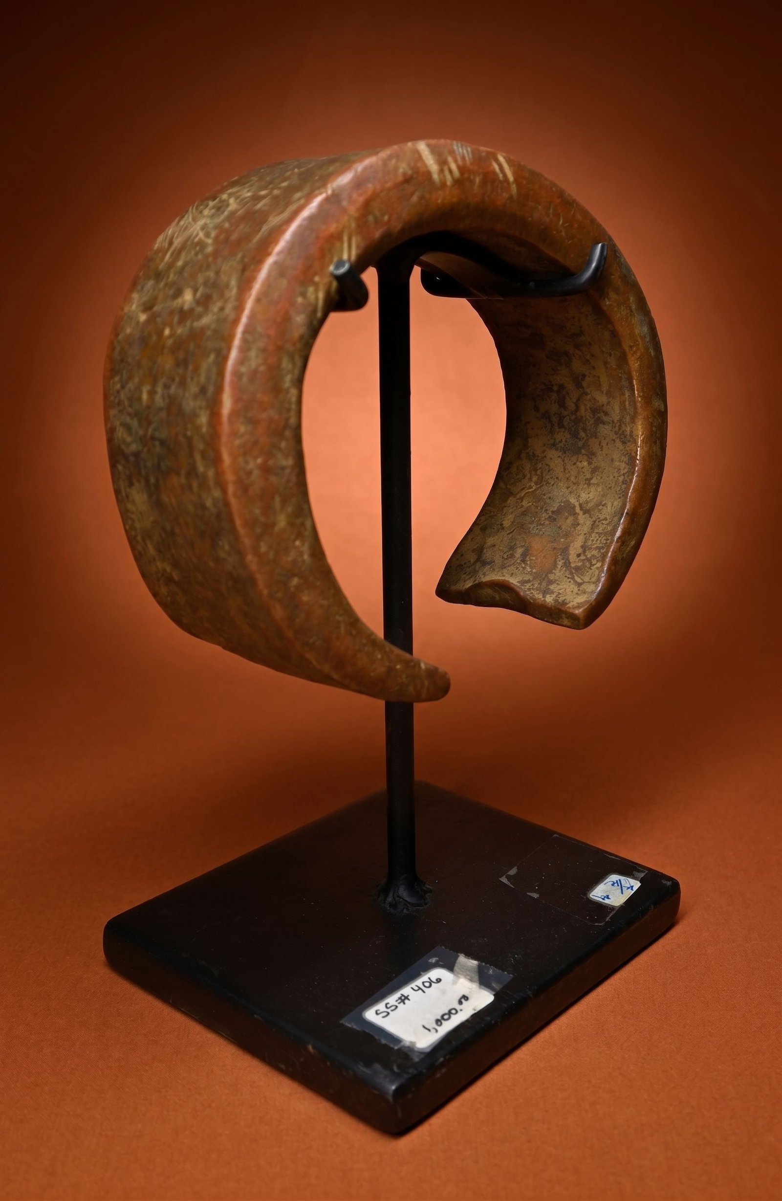 A Mongo Currency Anklet On Base: This is a heavy and thick antique Konda or Currency form, in the shape of an anklet that could have been worn as well. An old price tag states that it was sold at $1000.00. The use of imported copper 