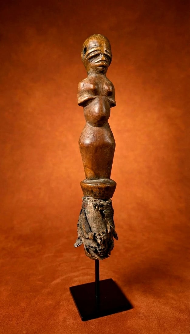 Old Makonde Flywhisk Handle with Ancestor Figure: A charming carved wooden Anthropomorphic handle with remains of reptile skin on the bottom where the whisk was once attached. Well worn showing obvious age and field use. Makonde or possibly Makua peo