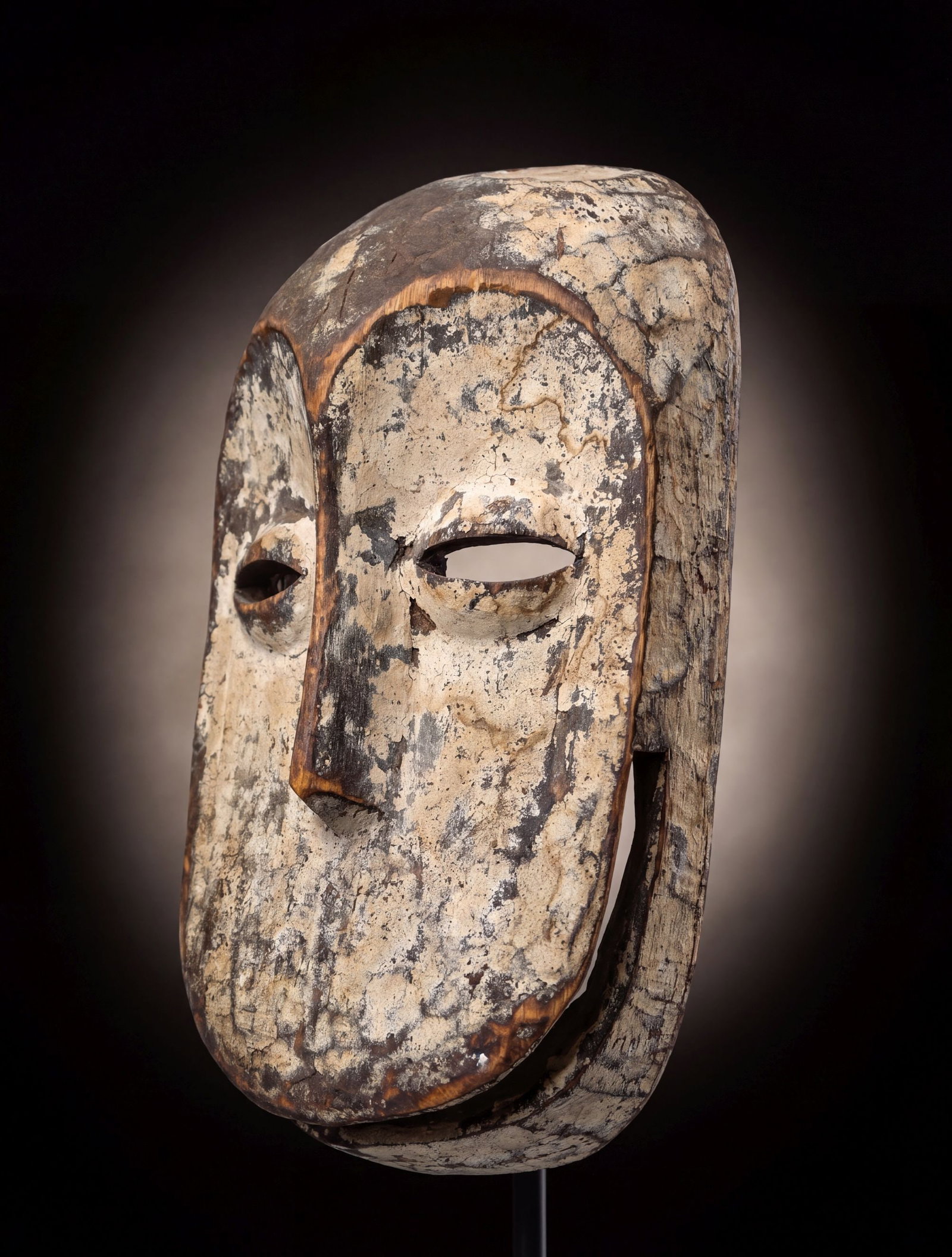 A White Hemba Monkey mask: A carved wooden mask painted white with kaolin clay pigments and with a charming smile and face, most likely a version of the Soko Mutu or Chimp masks, Hemba peoples, Congo, Africa. The mask measures 