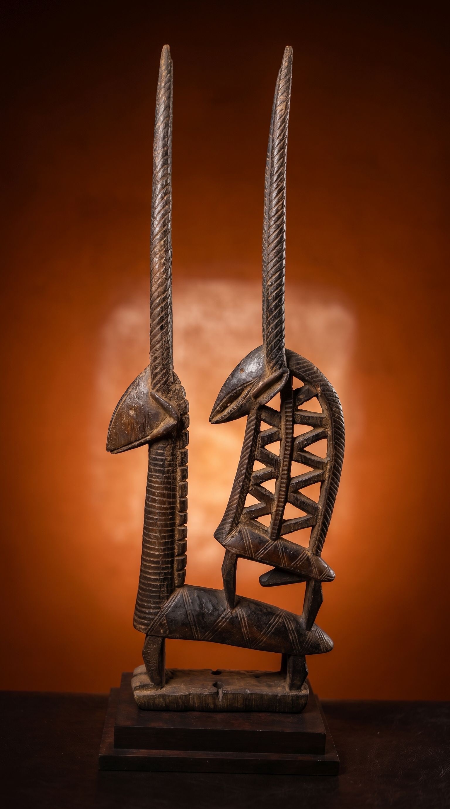 A Tall Bambara Chiwara Antelope Headdress: A tall and slender carved wooden antelope sculpture / headdress with a highly stylized male and female pair represented, all carved from a single piece of wood. Bambara / Bamana peoples, Mali, West Af