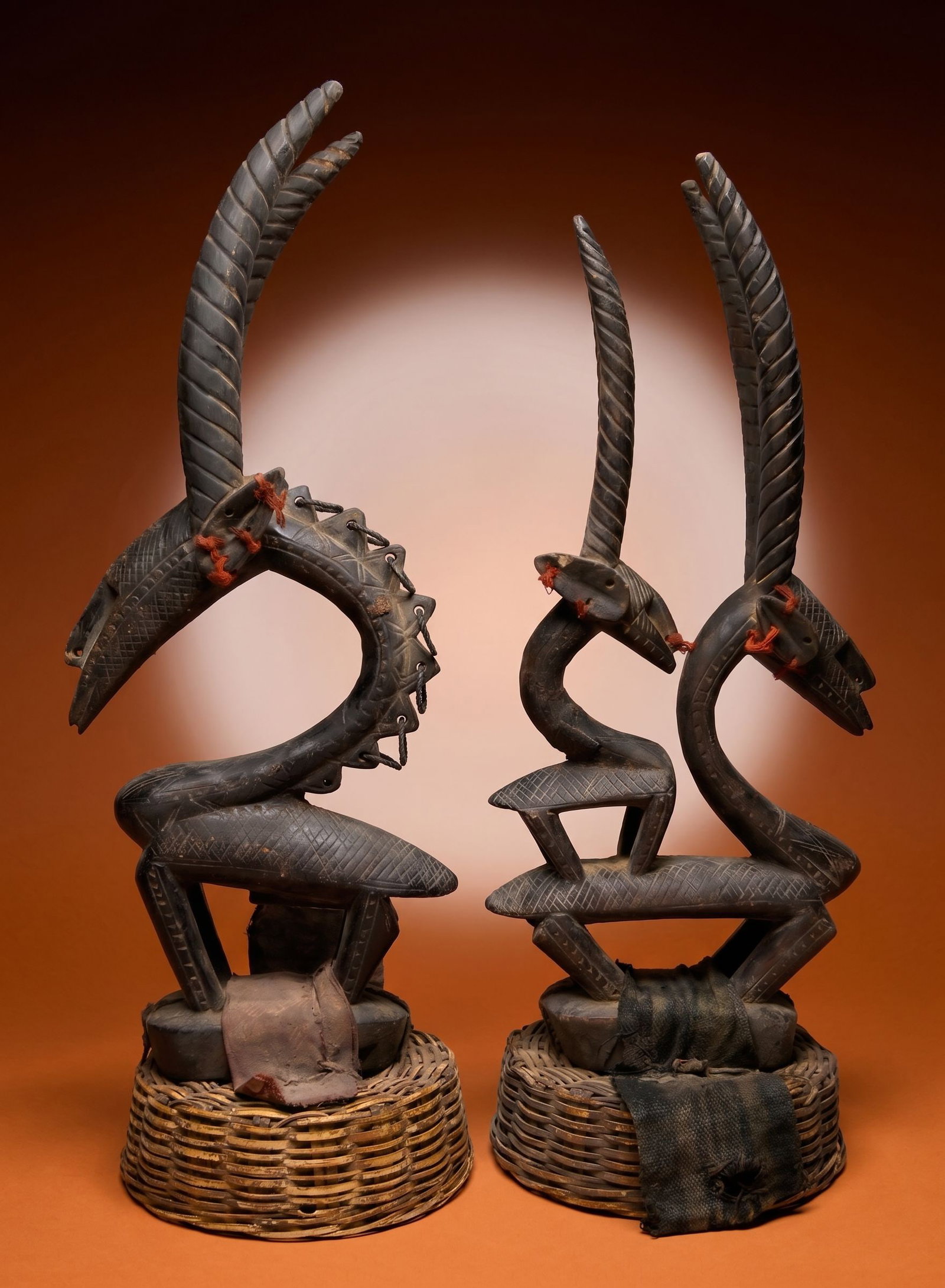 A Pair of Bambara Chiwara Antelope Dance Headdress: This lot is a pair of slender carved wooden antelope sculptures / headdress with a highly stylized male and female with child family represented, each carved from a single piece of wood. Bambara / Bam