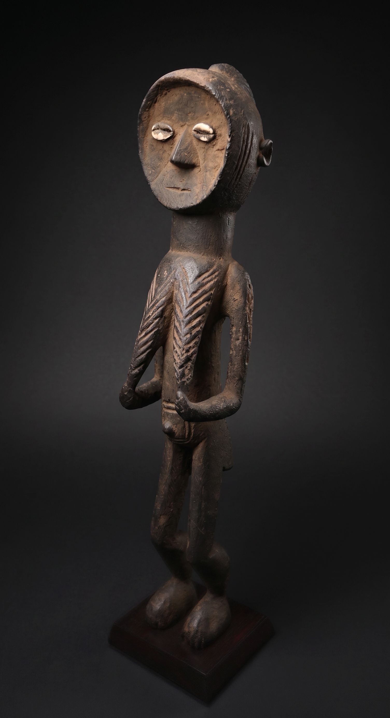 A Toma Female Sculpture: A highly stylized carved wooden female effigy with a wonderful exaggerated face and form. Toma peoples, Guinea, West Africa. The sculpture measures 24 inches tall on its custom 5x5 inch wooden base.