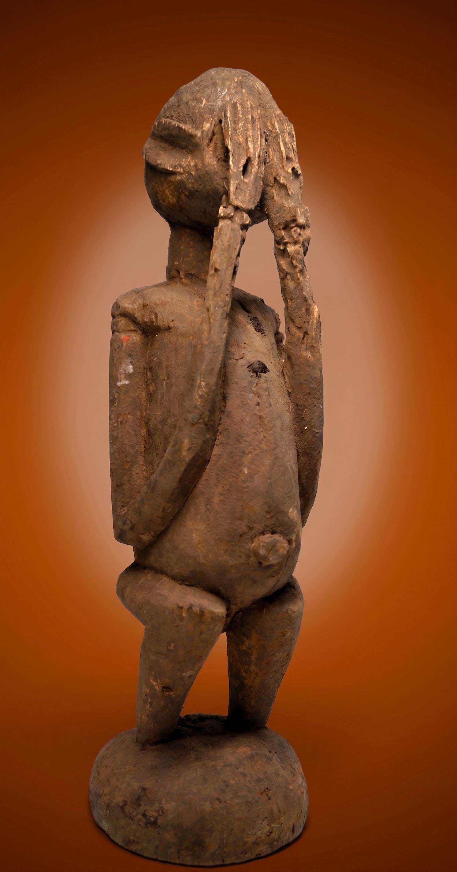 A Dogon Mourning Sculpture: A sculpture of an ancestor known as Djougou Sirou, shown in mourning or shame for violating the earth and sewing forbidden seeds which brings the aspect of death to mankind. The sculpture is heavily w