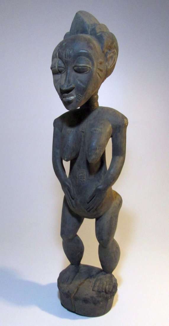 Large Baule female idol ~ Ex Steve Tobin Collection: Old vintage example of the Baule arts of west Africa. Excellent older carving with age and wear.Condition Report: Very well weathered and worn, stress fractures and wear, in fair condition.Provenance: