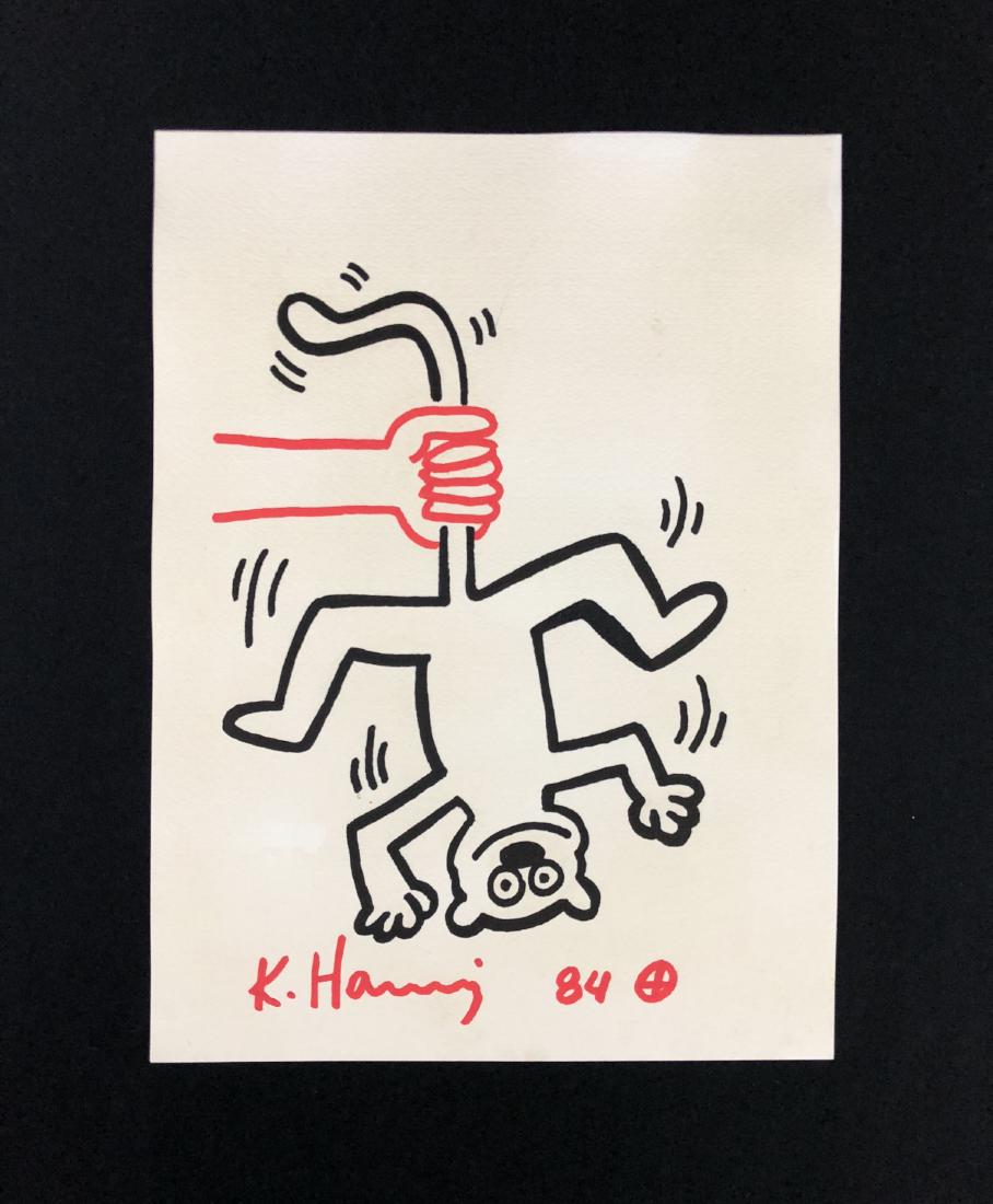 Keith Haring (American, 1958 -1990) -- Hand Drawn Ink: This lot consists of a HAND DRAWN ink on paper, Hand Signed "K. Haring" and dated "84", with a small crosshair at the end of the artist's signature. Image depicts an inverted monkey being held by a si