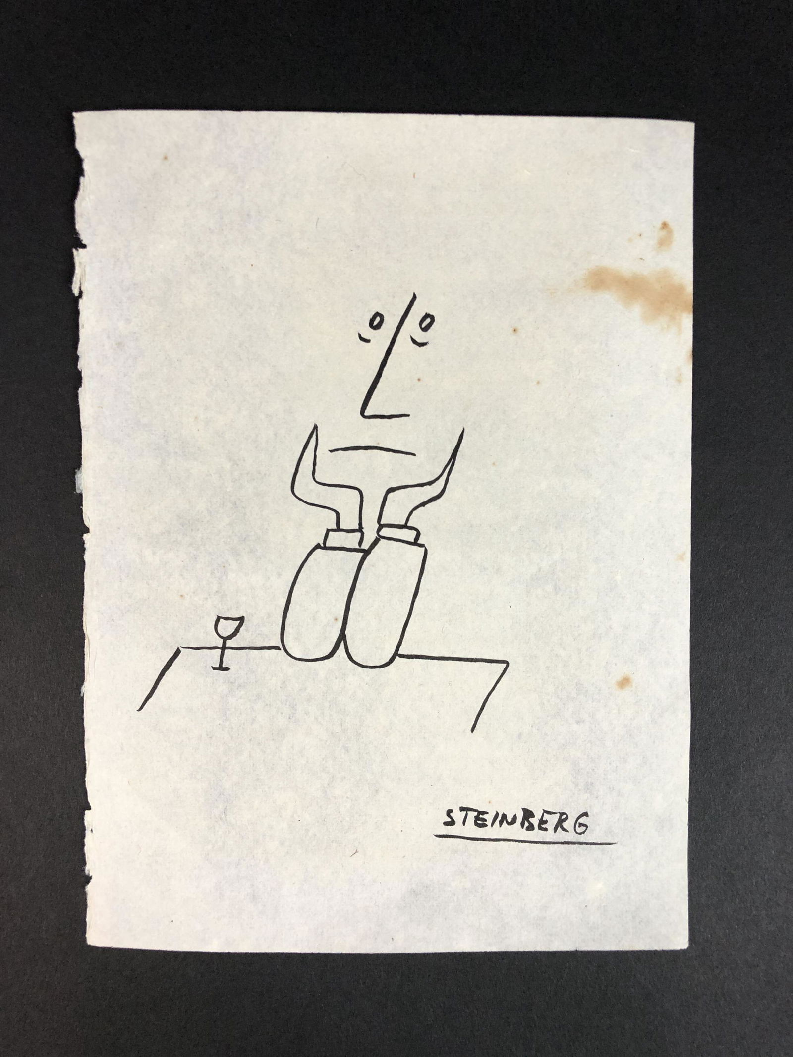 Saul Steinberg (Romanian, 1914-1999) - Ink on Paper: This lot consists of an ink illustration on paper, done in the minimalist style of Saul Steinberg (Romanian, 1914-1999). Image depicts a man sitting at a table with a wine glass and his chin in his ha