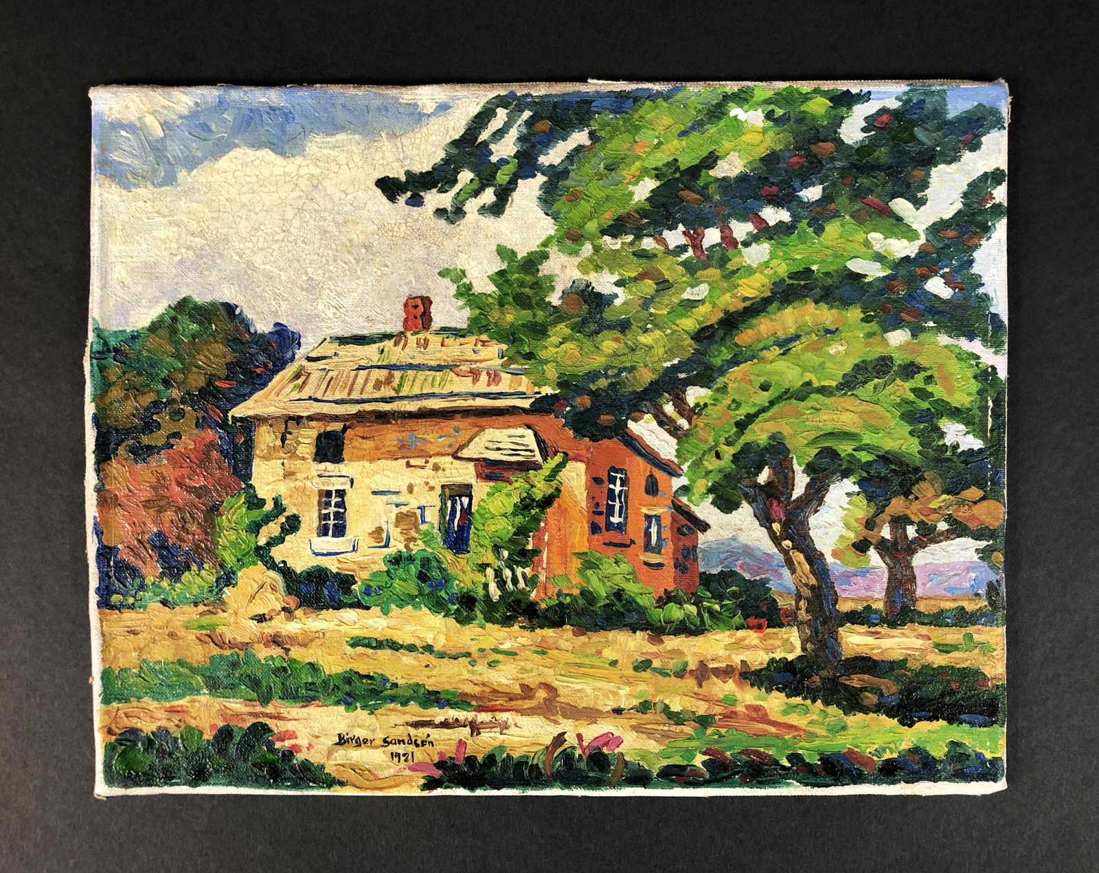 Birger Sandzen - Oil on Canvas Board (style of): This lot consists of an unframed oil painting on canvas board, done in the style of Birger Sandzen (Swedish-American, 1871-1954). Image depicts a quaint cottage sheltered beneath a lush tree. Deep col