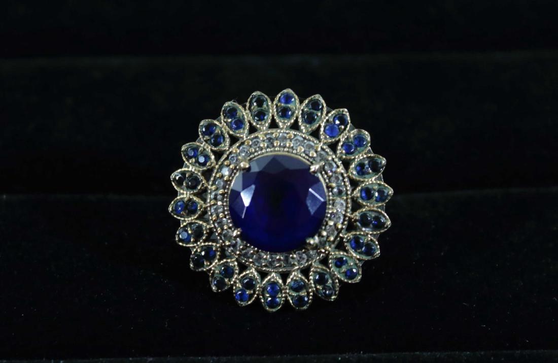 Victorian Flower Ring with Blue Spinel Pave: Victorian Flower Ring with Blue Spinel Pave and White Zircon Halo. Blue spinel leaves finish the edges. Ring Size: 8.5