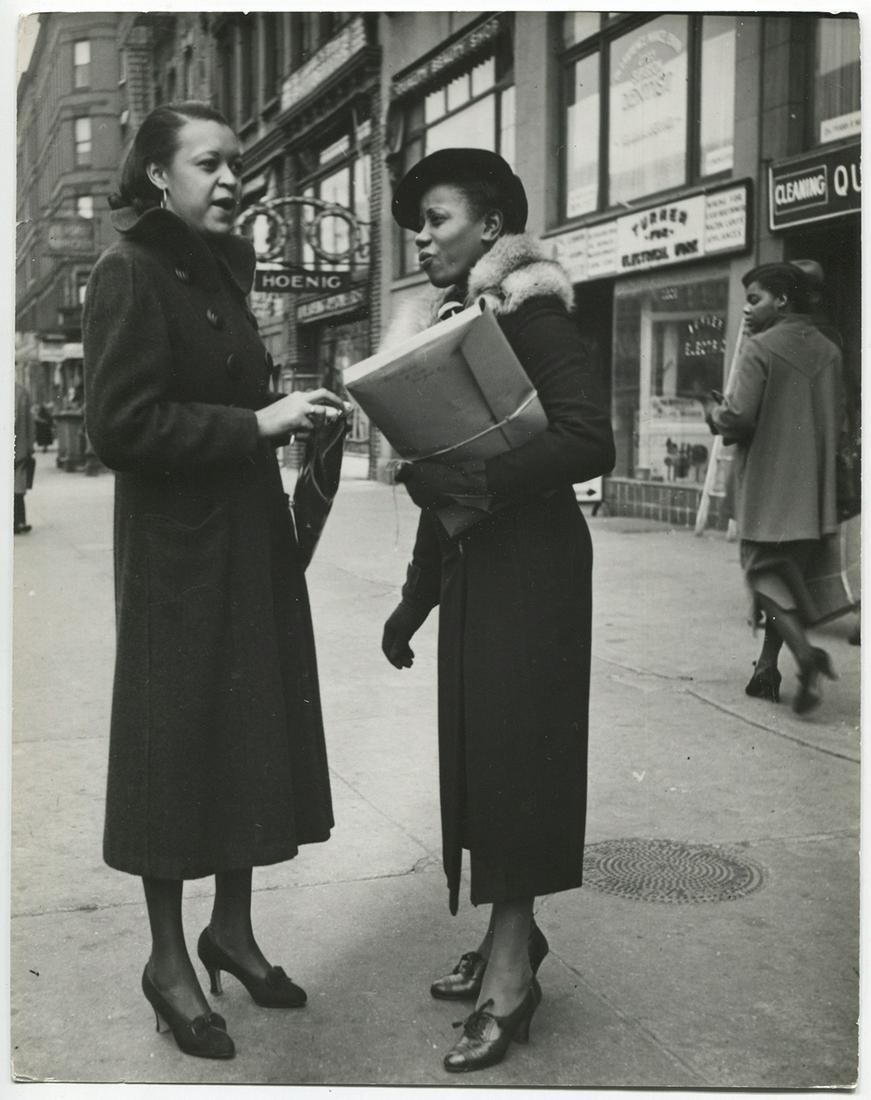 John Gutmann. Black Women , NYC: John Gutmann. Black women shoppers chat on the street, NYC, 1936. Vintage 9 7/8 x 7 ¾ inches ferrotyped gelatin silver print on single weight paper, with an original snipe attachedÂ—Â“The Negro