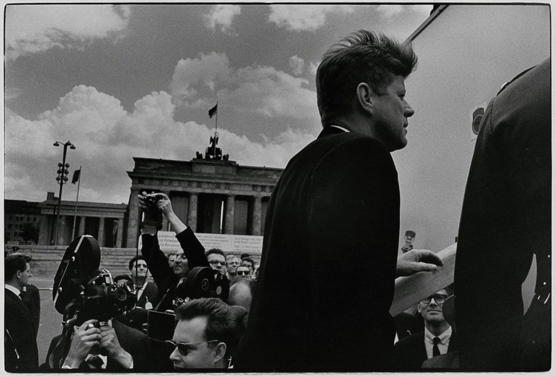 J.F.K. AT BRANDENBURG GATE, 1963.: J.F.K. AT BRANDENBURG GATE, 1963. 12 x 16 gelatin silver print by Will McBride. Signed in pencil verso with inscription "John F. Kennedy and Brandenburg Gate/ Berlin, 1963, for the 'I, Will McBride' B