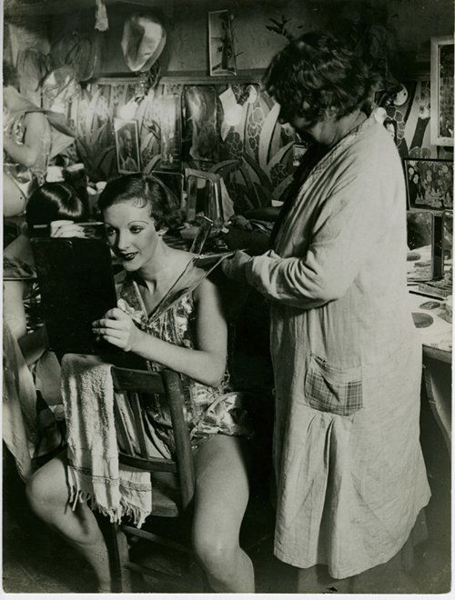 BRASSAI, DRESSING ROOM AT THE FOLIES BERGERE: 91/4 x 6 7/8- inch gelatin silver print, ferrotyped, on single weight paper, vintage 1932, with Brassai’s “rue de la Glacire” stamp and pencil “Die Loge der Girls” on verso. Slight bends on