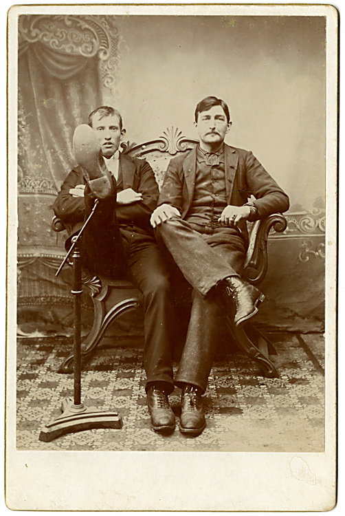 Showing the bottom of his shoe.: Showing the bottom of his shoe. It is held up by the posing stand. These two wear the same type of boot. Dated Dec. 30, 1898 in pen with “Home Sweet Home” and their initials. No maker indicated.