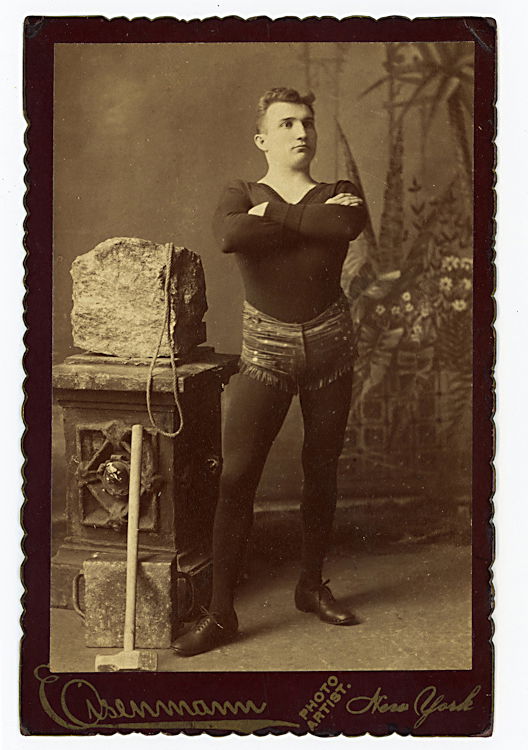Circus strong man D. A. Hall in Connellsburgh,: Circus strong man D. A. Hall in Connellsburgh, Pennsyvania [pencil verso.] There is a mallet with which he smashes the rock. By Eisenmann.