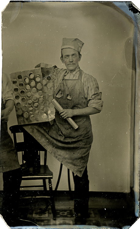 A man with a cylinder with which he punches out: A man with a cylinder with which he punches out circles. He holds a 3-sided box that has the circular holes on two sides. What is it? Please let me know. Uncased CDV size tintype.