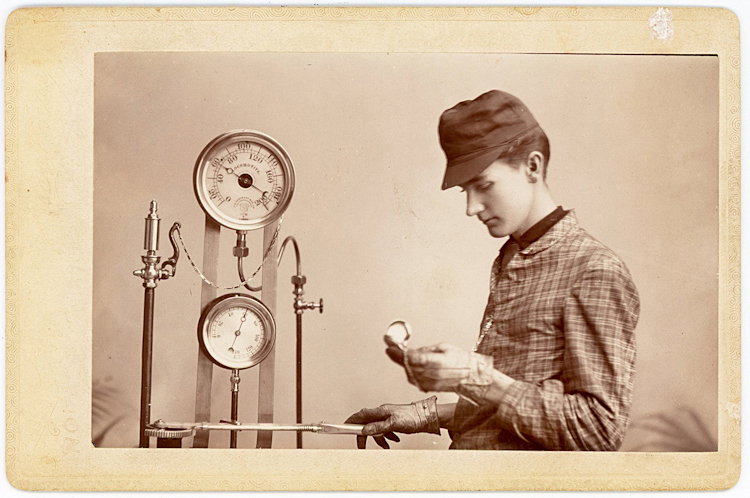 A railroad engineer, with pressure valves and meters.: A railroad engineer, with pressure valves and meters. He looks down at some object. Cabinet card by Thompson, Cameron, Missoui.