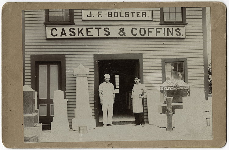 Makers of caskets and coffins.: Makers of caskets and coffins. The proprietors stand in the doorway. No maker is indicated, but the upright board on the right suggests this is Norway, Missouri.