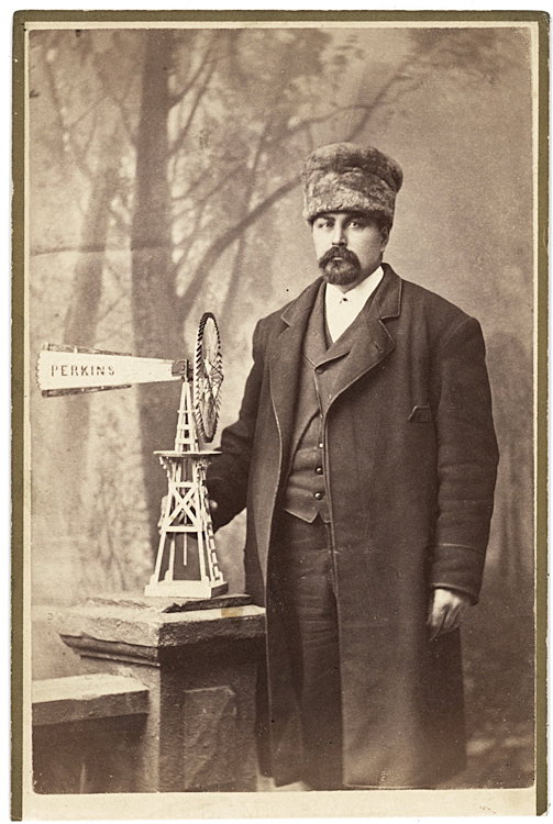 The inventor of a windmill.: The inventor of a windmill. He has a model on the balustrade. It is curious that for his occupational portrait he chooses to be dressed for the snowy weather represented by the backdrop. He must be Pe