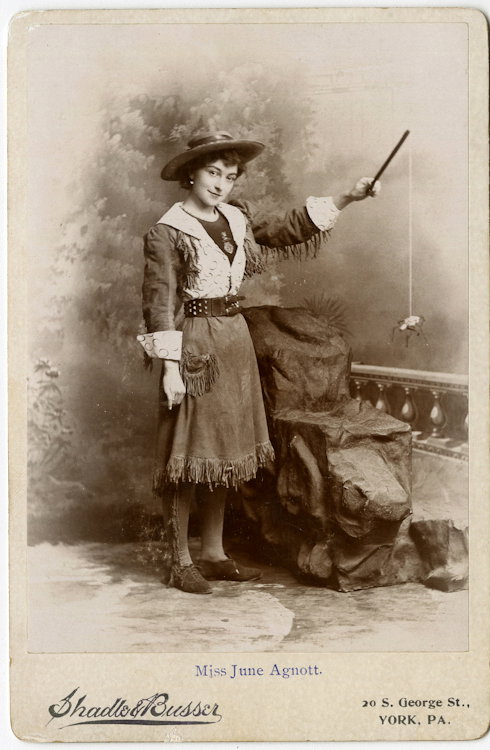 Holding a spider.: Holding a spider. Actress June Agnott in Western garb holds a spider suspended from a stick. She performed in Western-theme productions, often with animals. By Shadlo & Busser, York, Pennsylvania. Cle