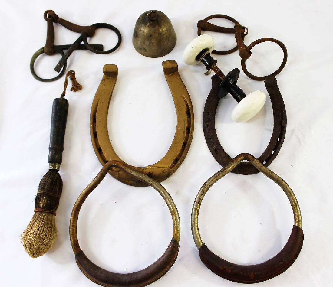 Assortment of Horsehoes; old Doorknob; stirrups: Two horse bits; doorknow with porcelain handles; two sitrripus; a small metal bell; an old hand brush; all of these items are vintage/antique